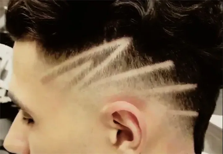 Lightning-bolt hair design shaved into a fade at Clever Barber