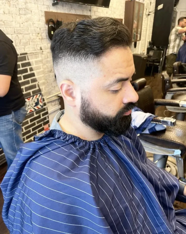 Skin fade with a full, sharply lined beard