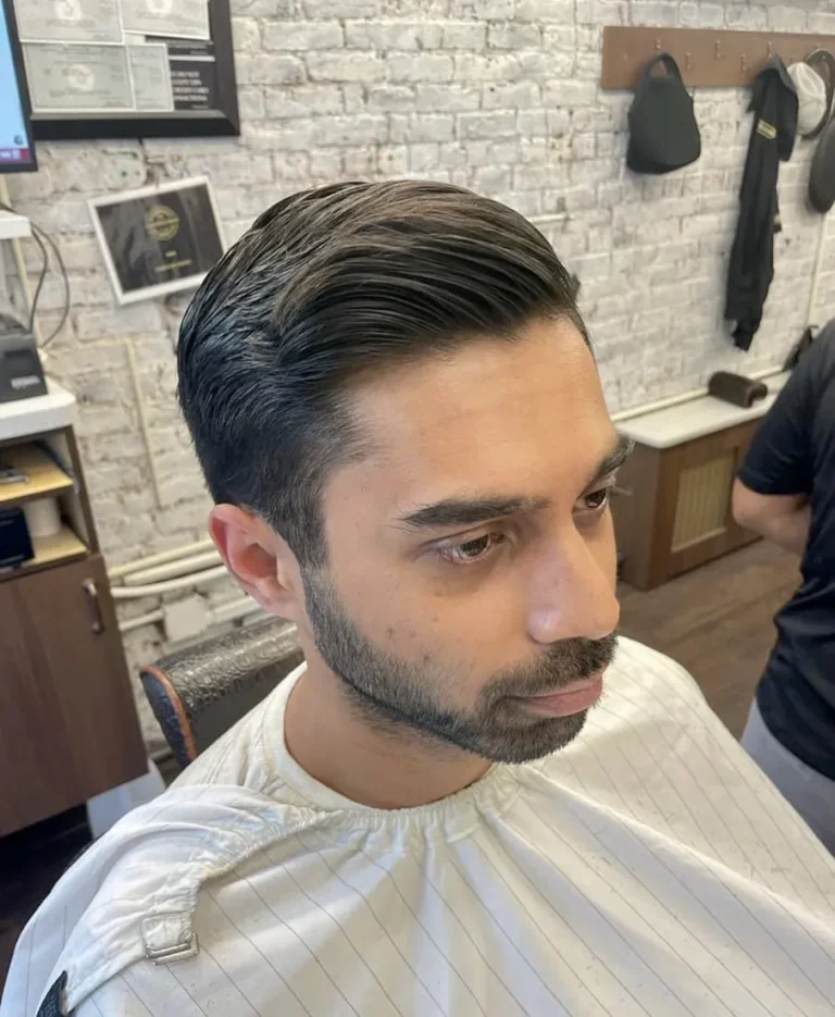 Slicked-back cut with a sculpted beard